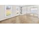 Well-lit living room featuring hardwood floors, white trim, built-in shelving, and large windows at 1133 Bloom Wood Ln, Matthews, NC 28105