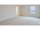 Neutral bedroom with plush carpeting, a window for natural light, and a spacious closet at 115 Dorian Pl, Troutman, NC 28166