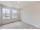 Bright bedroom with two large windows offering natural light, complemented by soft carpeting at 115 Dorian Pl, Troutman, NC 28166