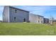 Spacious backyard with lush green grass and a view of the blue and grey siding of the two-story home at 116 Dorian Pl, Troutman, NC 28166