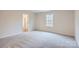 Neutral bedroom with a large window and en suite bathroom with shower at 116 Dorian Pl, Troutman, NC 28166