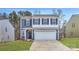 Charming two-story home features a blue and white exterior, attached two-car garage and landscaped yard at 116 Dorian Pl, Troutman, NC 28166