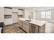 Bright kitchen with white cabinets, gray backsplash, stainless steel appliances, and large kitchen island at 116 Dorian Pl, Troutman, NC 28166