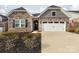Charming stone and siding exterior featuring a two-car garage and landscaped front yard at 12609 Twilight Dr, Mint Hill, NC 28227