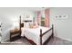 Cozy bedroom features a classic bed frame, soft carpeting, and a bright window with elegant pink curtains at 128 Woodhall Way, Troutman, NC 28166