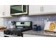 Modern kitchen features stainless steel appliances, granite countertops, and sleek white cabinetry at 128 Woodhall Way, Troutman, NC 28166