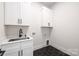 Laundry room with cabinets, hexagon tile floor, quartz countertop, and stainless steel sink at 17201 Green Hill Rd, Charlotte, NC 28278