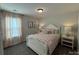 Cozy bedroom with a white bed frame, neutral walls and curtains, and accent pillows at 228 Heatherland Dr, Rock Hill, SC 29732