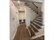Inviting hallway with staircase featuring iron balusters, wood floors, and a convenient mudroom area at 228 Heatherland Dr, Rock Hill, SC 29732