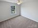 Cozy bedroom with neutral carpet, natural light from a window, and a ceiling fan, creating a warm atmosphere at 246 Tail Race Ln, Fort Mill, SC 29715