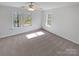 Spacious bedroom with neutral carpet and two windows allowing natural light, complemented by a ceiling fan at 246 Tail Race Ln, Fort Mill, SC 29715