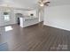 Open-concept living room featuring wood-look floors, white cabinets, stainless steel appliances, and ample natural light at 246 Tail Race Ln, Fort Mill, SC 29715