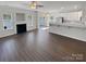 Open-concept living room with a fireplace, and the kitchen features white cabinets and stainless steel appliances at 246 Tail Race Ln, Fort Mill, SC 29715