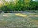 Large grassy backyard with new mulch and young trees and landscaping against wooded backdrop at 2617 Manor Stone Way, Indian Trail, NC 28079