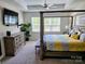 Primary bedroom featuring a four poster bed, dresser, side table, and tray ceiling at 2617 Manor Stone Way, Indian Trail, NC 28079