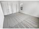 Neutral carpeted bedroom with a window and closet doors, providing ample storage and natural light at 2643 Meadow Knoll Dr, Charlotte, NC 28269