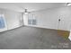 Spacious living room with neutral carpet, large windows, ceiling fan, and an inviting open floor plan at 2643 Meadow Knoll Dr, Charlotte, NC 28269