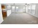 Bright living room featuring neutral carpet, ceiling fan, and natural light from large windows at 2643 Meadow Knoll Dr, Charlotte, NC 28269