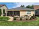A home's backyard with a screened patio, outdoor grill, and stone retaining wall with a fire pit at 305 Hemlock Bluff Ct, Denver, NC 28037