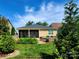 A home's backyard featuring a screened in patio, an outdoor grill, landscaping, and a stone retaining wall at 305 Hemlock Bluff Ct, Denver, NC 28037
