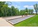 Outdoor bocce ball court surrounded by lush greenery, offering a recreational amenity at 305 Hemlock Bluff Ct, Denver, NC 28037
