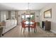 Well-lit dining area featuring a modern chandelier, sliding glass doors, and comfortable seating for four at 305 Hemlock Bluff Ct, Denver, NC 28037