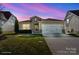 Charming single Gathering home featuring manicured lawn and two-car garage against a colorful sky at 305 Hemlock Bluff Ct, Denver, NC 28037