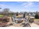 An outdoor stone fire pit area with rocking chairs and a fence at 305 Hemlock Bluff Ct, Denver, NC 28037