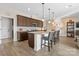 Open kitchen featuring dark wood cabinets, granite countertops, a kitchen island, pendant lighting, and stainless steel appliances at 305 Hemlock Bluff Ct, Denver, NC 28037