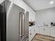 Modern kitchen extension with stainless steel fridge, white cabinets, and herringbone wallpaper at 324 Patternote Rd, Mooresville, NC 28117