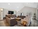 Open living room with vaulted ceilings, comfortable sofas, and scenic backyard views at 324 Patternote Rd, Mooresville, NC 28117