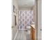 Well-lit bathroom with a shower featuring a patterned curtain, plus modern gray flooring at 3247 Bamburgh Ct, Charlotte, NC 28216