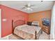 Cozy bedroom featuring a TV, ceiling fan, patterned bedding, and a mix of warm color tones at 3247 Bamburgh Ct, Charlotte, NC 28216
