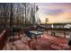 View of the deck with grill, table, and chairs with surrounding trees at 3247 Bamburgh Ct, Charlotte, NC 28216