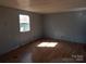 An empty room with a window letting in natural light and hardwood floors at 335 Lake Landing Dr, Salisbury, NC 28146