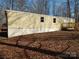 Exterior of this mobile home features siding and a charming wooden deck, set in a serene wooded landscape at 335 Lake Landing Dr, Salisbury, NC 28146
