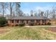 Charming brick home featuring a well-manicured lawn, mature trees, and classic blue shutters at 410 Deerwood Dr, Gastonia, NC 28054