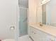 This brightly lit bathroom has a glass enclosed shower and a white vanity at 4405 Simsbury Rd, Charlotte, NC 28226