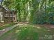 This backyard features a grassy lawn and shade trees at 5011 Sharon Rd # J, Charlotte, NC 28210