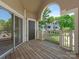 Spacious, shaded balcony featuring wooden flooring, white railings, and a view of the neighborhood at 5011 Sharon Rd # J, Charlotte, NC 28210