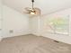 Carpeted bedroom with a ceiling fan, window with blinds, and a neutral color scheme at 5011 Sharon Rd # J, Charlotte, NC 28210