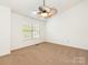 Carpeted bedroom featuring a ceiling fan, window with blinds, and neutral color scheme at 5011 Sharon Rd # J, Charlotte, NC 28210