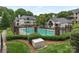 Apartment complex featuring a large in-ground pool and surrounding mature trees at 5011 Sharon Rd # J, Charlotte, NC 28210