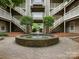 Beautiful courtyard with a fountain feature surrounded by mature trees and walkways at 5011 Sharon Rd # J, Charlotte, NC 28210
