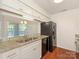 Modern kitchen featuring white cabinets, granite countertops, and stainless steel appliances for a sleek design at 5011 Sharon Rd # J, Charlotte, NC 28210