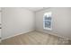Minimalist bedroom with carpet, white walls, base molding, and a single window allowing natural light at 5084 Parkview Way, Matthews, NC 28104