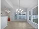 Dining area featuring a modern chandelier, tile floors, natural lighting, and a glass patio door at 5084 Parkview Way, Matthews, NC 28104