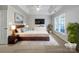 Spacious main bedroom featuring a tray ceiling, large window, and modern furniture at 5084 Parkview Way, Matthews, NC 28104
