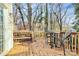 Back deck perfect for outdoor dining with a table, chairs, and grill; surrounded by trees for privacy at 5323 Dewmorn Pl, Charlotte, NC 28269