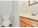 Half bathroom featuring a wood cabinet and sink, a white toilet, and neutral wall paint at 5323 Dewmorn Pl, Charlotte, NC 28269